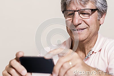Smartphone and senior man at home