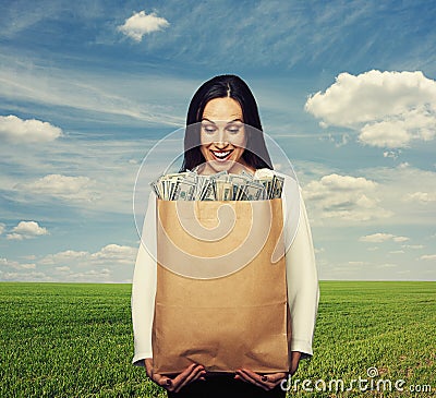 Smiley woman holding paper bag with money