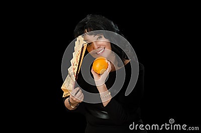 Smiling actress holds folding fan and orange