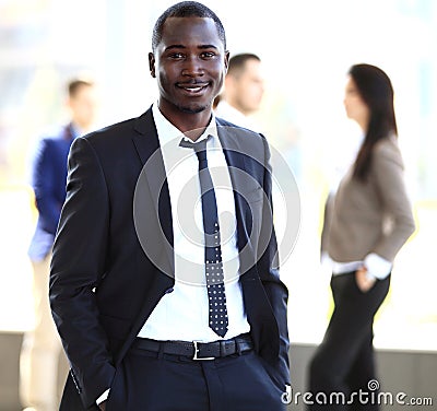 Smiling African American business man with executives working in background