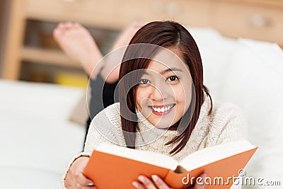 Smiling Asian woman enjoying a good book