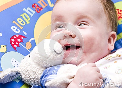 Smiling baby with soft toy