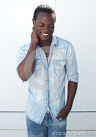 Smiling black man standing outdoors against white background