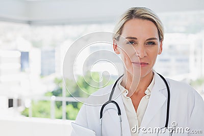 Smiling blonde doctor holding a clipboard