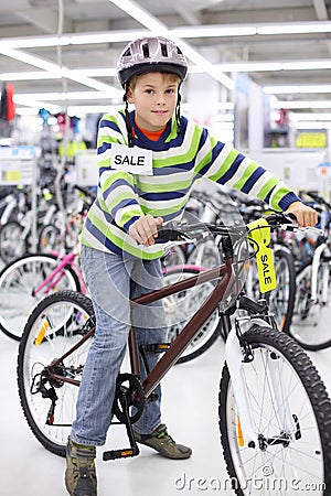 Smiling boy in helmet sits on bicycle