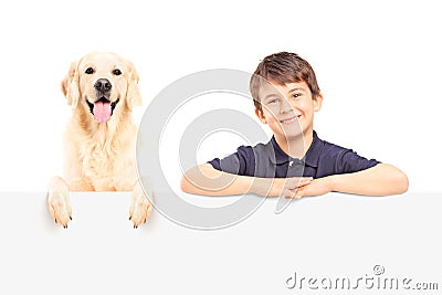 A smiling boy and Labrador retriever posing behind a panel