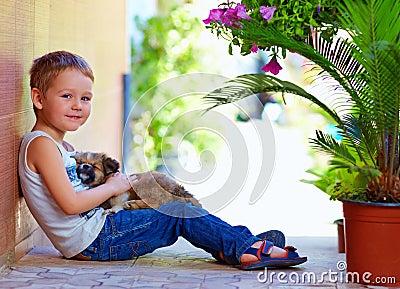 Smiling boy with sleeping puppy in hands