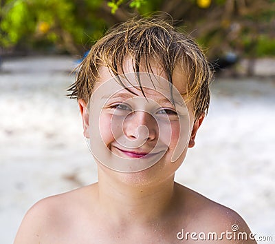 Smiling boy with wet hair at the beach