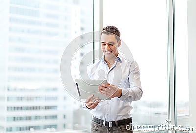 Smiling businessman with tablet pc in office