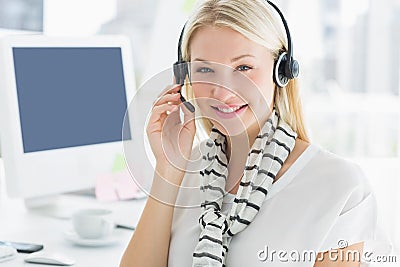Smiling casual young woman with headset in office
