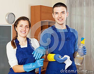 Smiling cleaners team cleaning floor