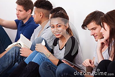 Smiling college student sitting with classmates
