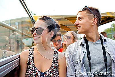 Smiling couple with camera traveling by tour bus