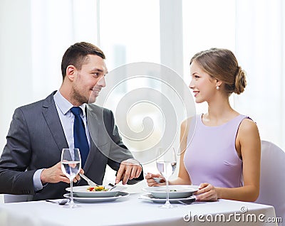 Smiling couple eating appetizers at restaurant