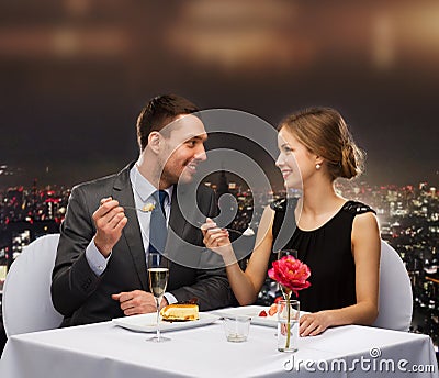 Smiling couple eating dessert at restaurant