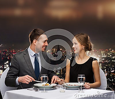 Smiling couple eating main course at restaurant