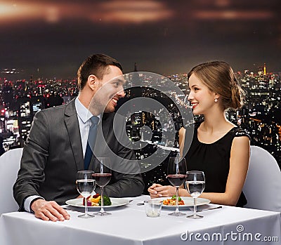 Smiling couple eating main course at restaurant