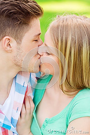 Smiling couple kissing and hugging in park