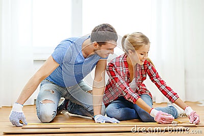 Smiling couple measuring wood flooring