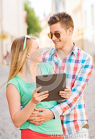 Smiling couple with tablet pc in city