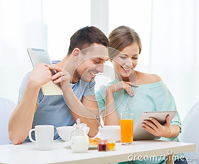 Smiling couple with tablet pc reading news