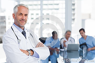 Smiling doctor with arms folded