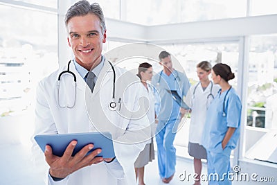 Smiling doctor holding digital tablet