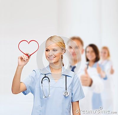 Smiling doctor or nurse drawing red heart