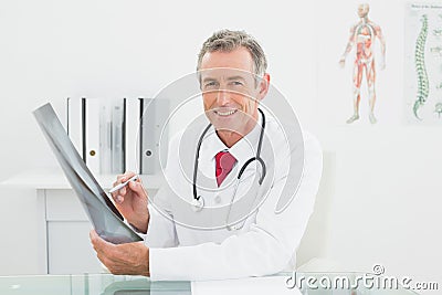 Smiling doctor with xray picture of lungs in office