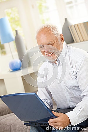 Smiling elderly man looking at computer screen