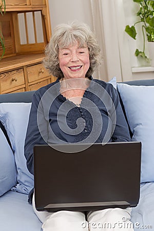 Smiling elderly woman with laptop