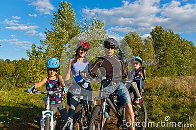 Smiling family cycling outdoors