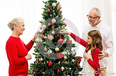 Smiling family decorating christmas tree at home