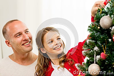 Smiling family decorating christmas tree at home