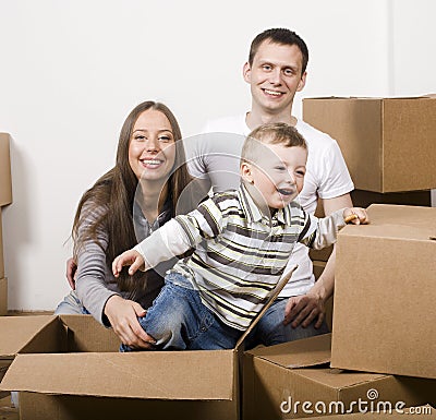 Smiling family in new house playing with boxes