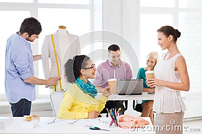 Smiling fashion designers working in office