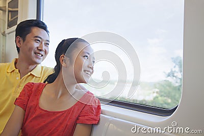 Smiling father and daughter looking through the window in the subway