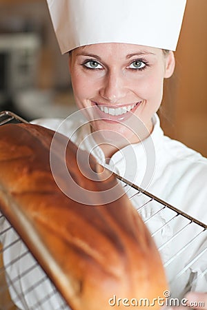 Smiling female chef baking bread