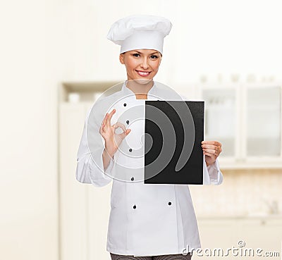 Smiling female chef with black blank paper