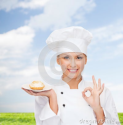 Smiling female chef with cake on plate