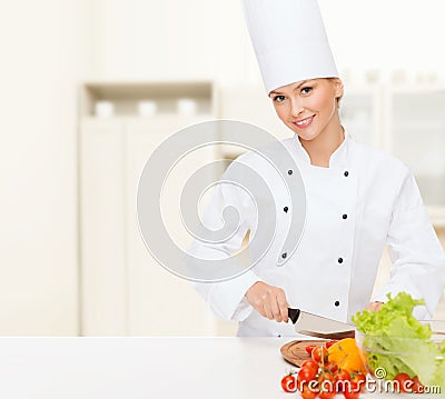 Smiling female chef chopping vagetables