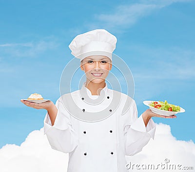 Smiling female chef with salad and cake on plates
