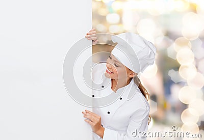 Smiling female chef with white blank board
