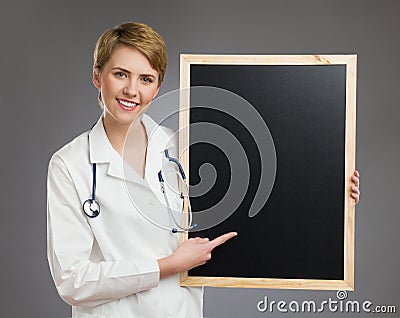 Smiling female doctor holding black board.