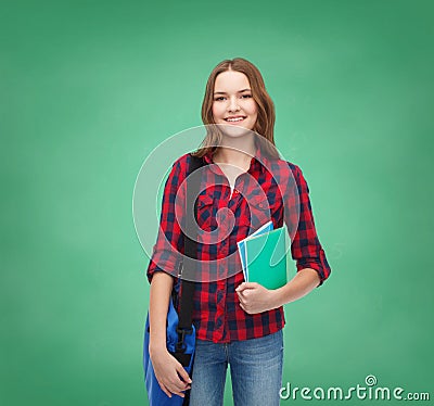 Smiling female student with bag and notebooks
