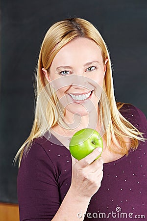 Smiling female teacher with apple