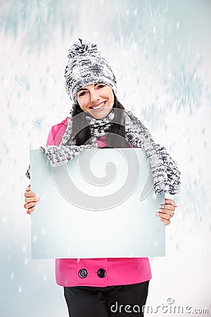 Smiling girl with a blank board and around snowing
