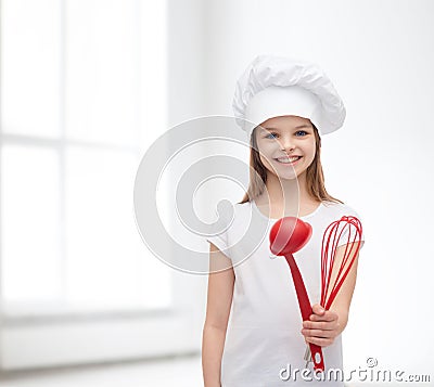 Smiling girl in cook hat with ladle and whisk