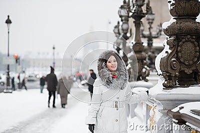Smiling girl enjoying rare snowy day in Paris
