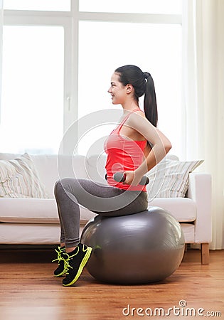 Smiling girl exercising with fitness ball